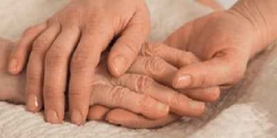 "Dłonie trzymające starszą osobę za rękę"