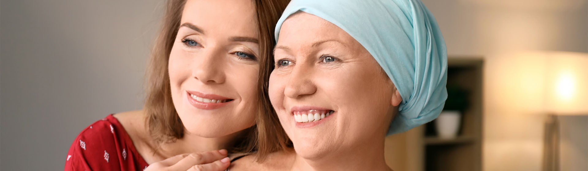Dwie osoby się uśmiechają. Jedna osoba ma na głowie opaskę.
