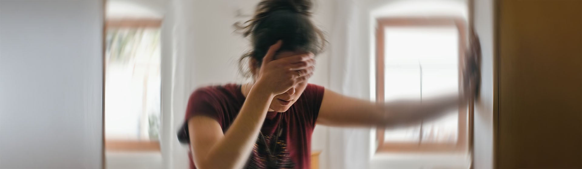 Osoba trzyma głowę w pomieszczeniu